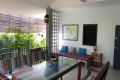 Inviting-terrace-with-a-stylish-dining-table-set-and-the-welcoming-entrance-of-the-house