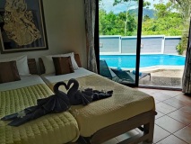 Bright-room-with-a-double-beds-offering-stunning-views-of-the-terrace-and-pool