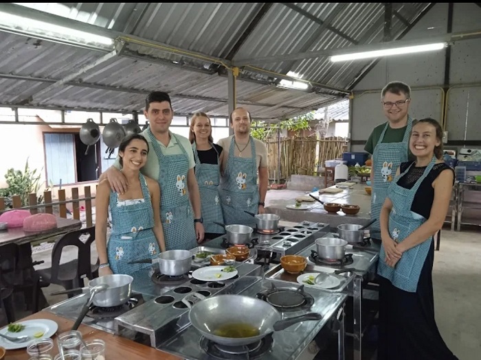 Group of learners preparing Pad Thai in Krabi cooking course
