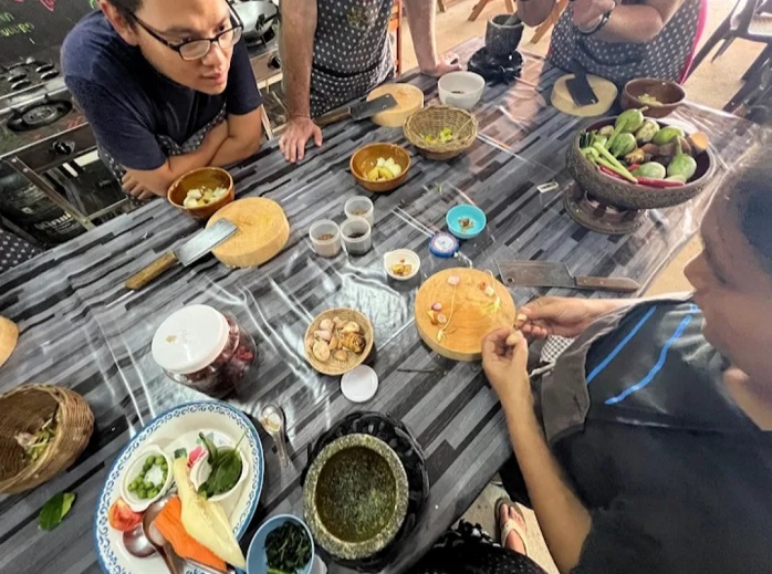 Students preparing and tasting Thai dishes in Learn Thai Cooking in Krabi class