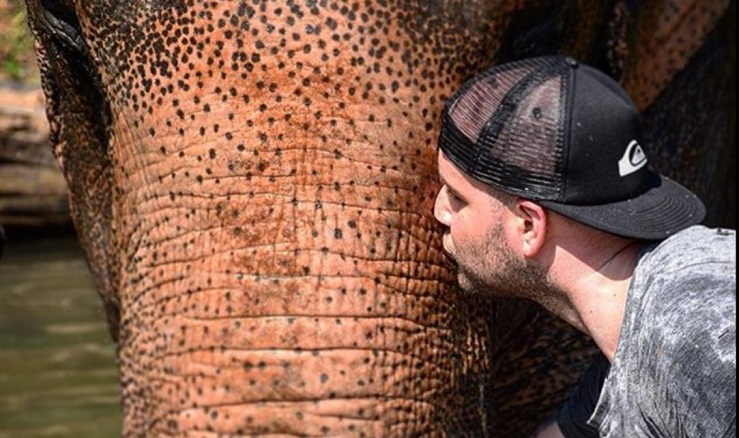 Visitor giving a loving kiss to an elephant at Krabi Elephants Sanctuary
